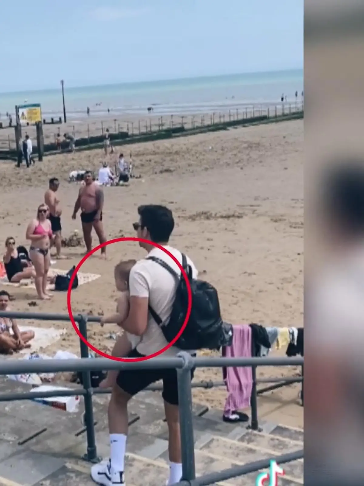 Dieser Mann ist auf der Suche. Und zwar nach der Mutter des Kindes, das er im Arm hält. Das hat er gefunden, ganz alleine, wie es gerade auf eine stark befahrene Straße zukrabbelt. Von der Mutter ist hier am Strand vom englischen Dymchurch keine Spur.
