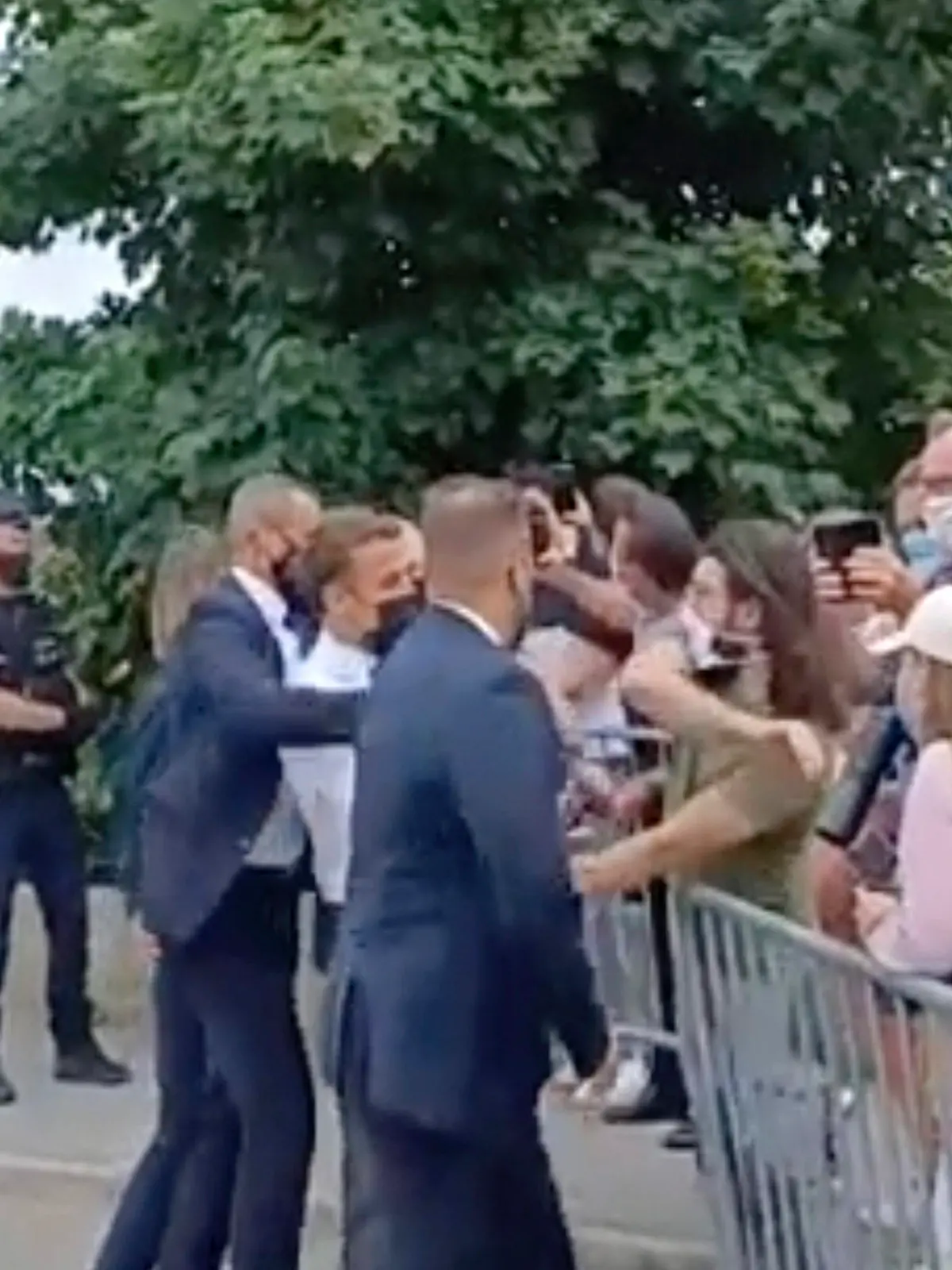 In this grab taken from video France's President Emmanuel Macron, centre, is slapped by a man, in green T-shirt, during a visit to Tain-l’Hermitage, in France, Tuesday, June 8, 2021. Macron denounced “violence” and “stupidity” after he was slapped in the face Tuesday by a man during a visit to a small town in southeastern France. The incident prompted a wide show of support for the head of state from politicians across the ideological spectrum. A video shows a man slapping Macron in the face and the president's bodyguards pushing the aggressor away as the head of state was quickly rushed from the scene in the town of Tain-l’Hermitage. (BFM TV via AP)