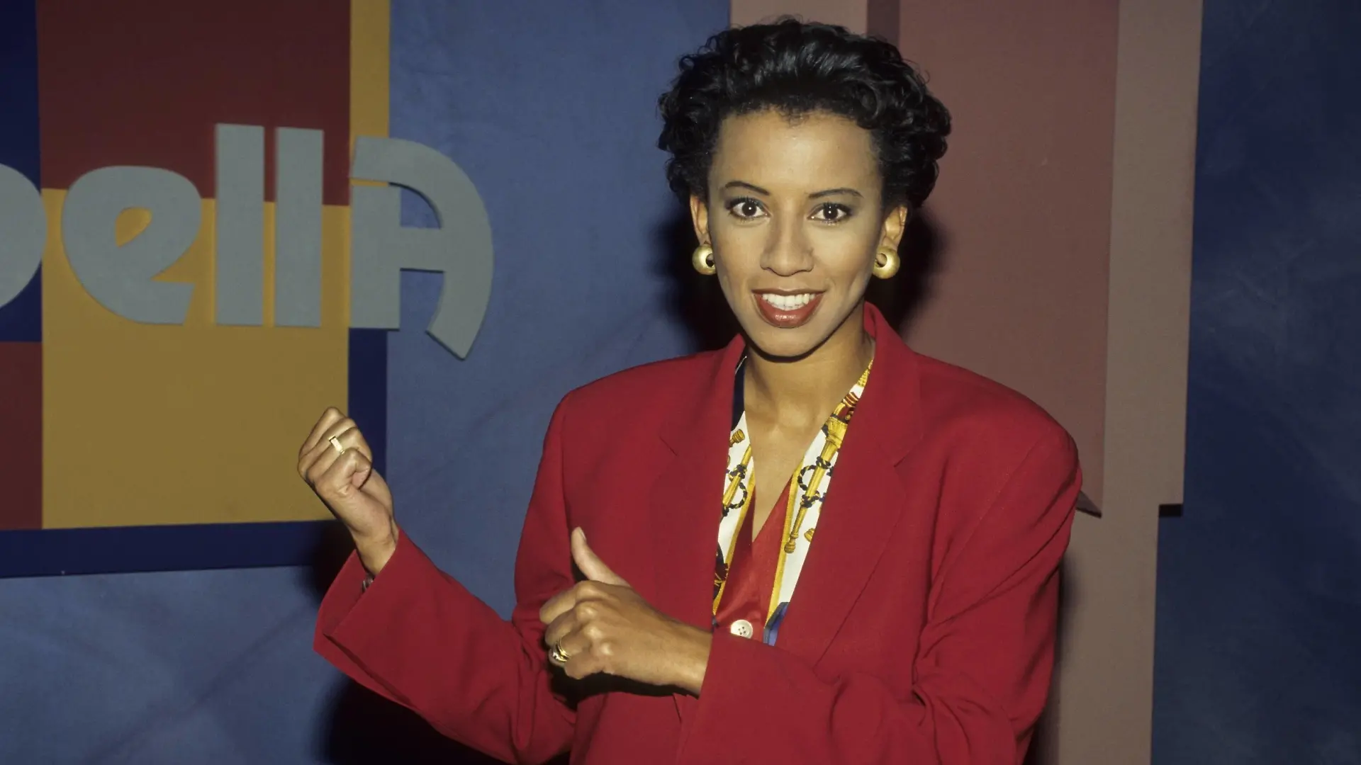 Arabella Kiesbauer 02/94 kück quer halb Logo lächelnd Kulisse seriös Blazer rot Frau Fernsehen Moderation Journalismus dunkelhaarig dunkelhäutig Schmuck Ohrring