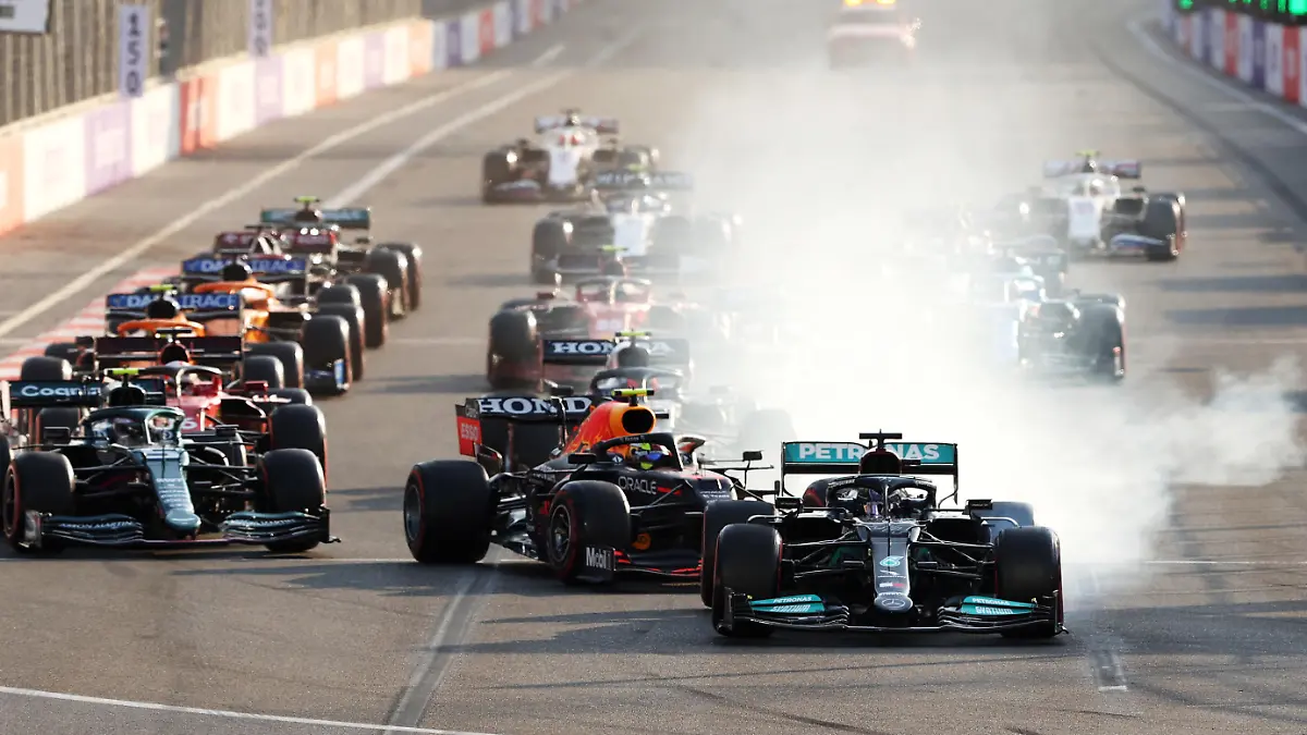 BAKU, AZERBAIJAN - JUNE 06: Lewis Hamilton of Great Britain driving the (44) Mercedes AMG Petronas F1 Team Mercedes W12 locks up under pressure from Sergio Perez of Mexico driving the (11) Red Bull Racing RB16B Honda into the first corner after the restart following a red flag period during the F1 Grand Prix of Azerbaijan at Baku City Circuit on June 06, 2021 in Baku, Azerbaijan. (Photo by Clive Rose/Getty Images)