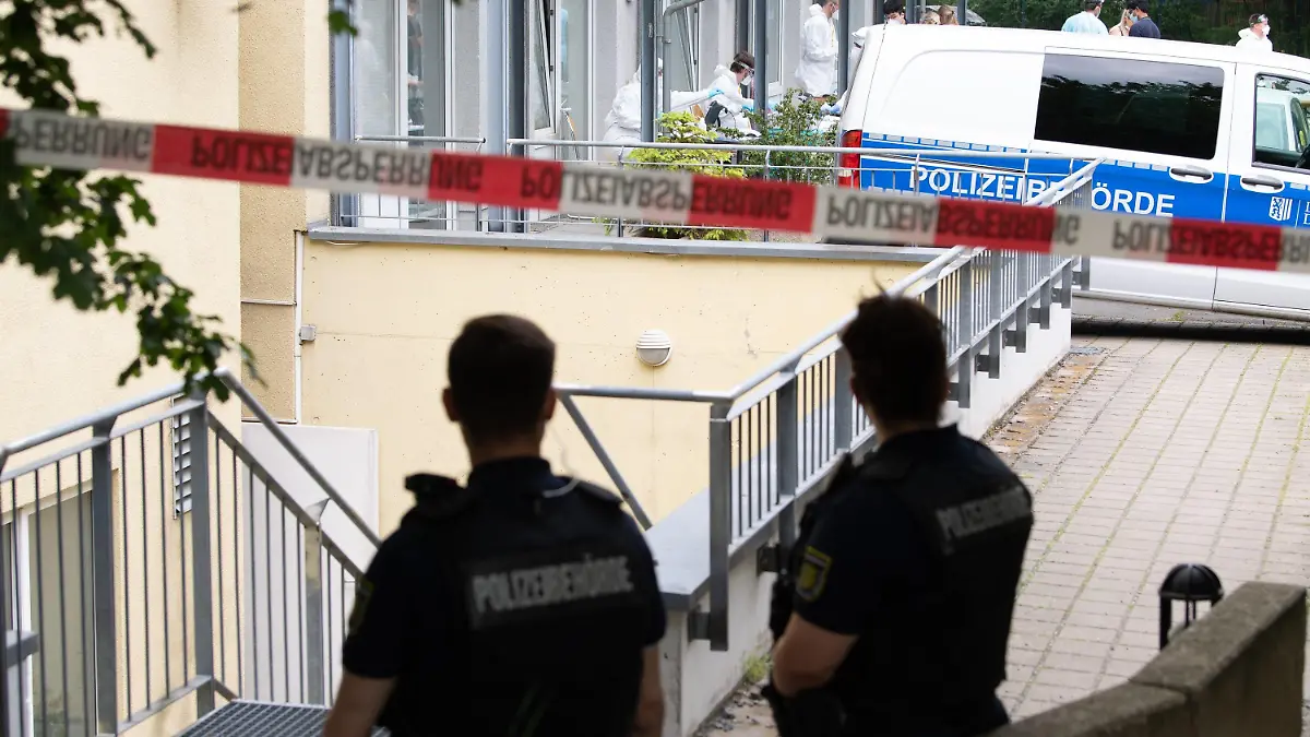 04.06.2021, Sachsen, Dresden: Polizisten stehen hinter einer Absperrung vor einem Studentenwohnheim im Dresdner Stadtteil Strehlen. Nach dem Tod eines an Covid-19 erkrankten Indien-Rückkehrers werden sämtliche Bewohner des Hochhauses auf das Coronavirus getestet. Zudem steht das Wohnhaus unter Quarantäne. Foto: Sebastian Kahnert/dpa-Zentralbild/dpa +++ dpa-Bildfunk +++
