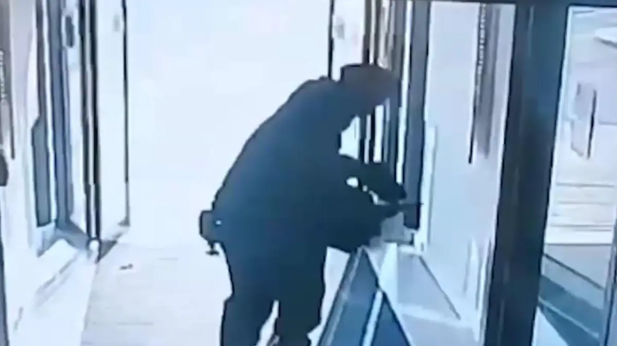 Hier hebt der Verdächtige die Waffe vom Boden auf.