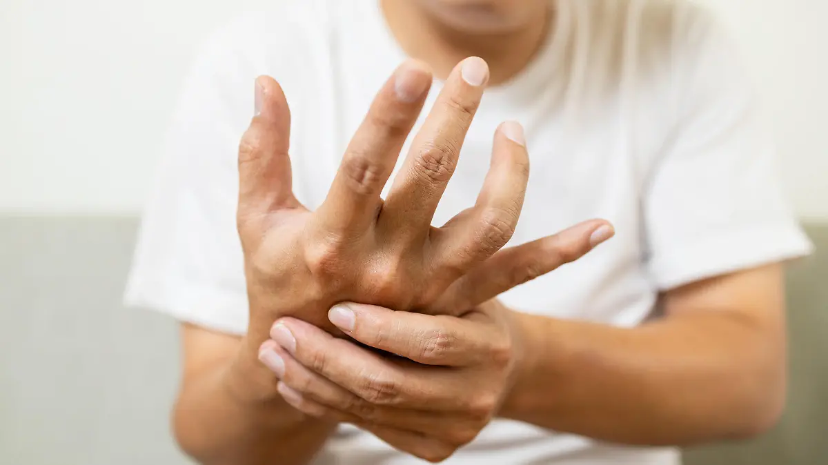 Close up,asian middle-aged man with shaking of Parkinson's disease,symptom of resting tremor,male patient holding her hand to control hands tremor,neurological disorders,brain problems,health care