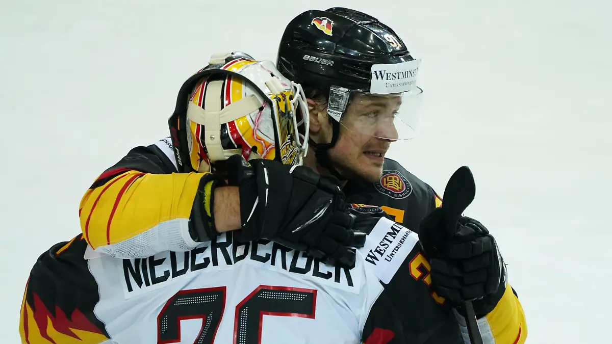 01.06.2021, Lettland, Riga: Eishockey: Weltmeisterschaft, Viertelfinale, Schweiz - Deutschland: Deutschlands Moritz Müller (hinten) und Torwart Mathias Niederberger umarmen sich nach dem Spiel. Die deutsche Eishockey-Nationalmannschaft gewann das Viertelfinale gegen die Schweiz 3:2 nach Penaltyschießen und spielt damit um die erste WM-Medaille seit 1953. Foto: Roman Koksarov/dpa +++ dpa-Bildfunk +++