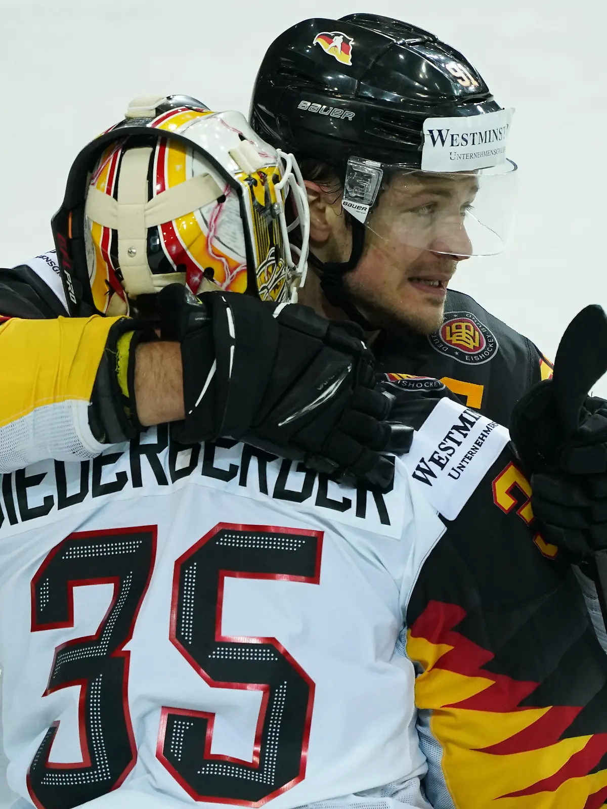 01.06.2021, Lettland, Riga: Eishockey: Weltmeisterschaft, Viertelfinale, Schweiz - Deutschland: Deutschlands Moritz Müller (hinten) und Torwart Mathias Niederberger umarmen sich nach dem Spiel. Die deutsche Eishockey-Nationalmannschaft gewann das Viertelfinale gegen die Schweiz 3:2 nach Penaltyschießen und spielt damit um die erste WM-Medaille seit 1953. Foto: Roman Koksarov/dpa +++ dpa-Bildfunk +++