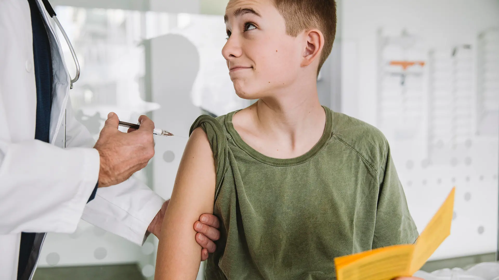 Doctor injecting a vaccine into teenagers arm model released Symbolfoto property released MFF05520