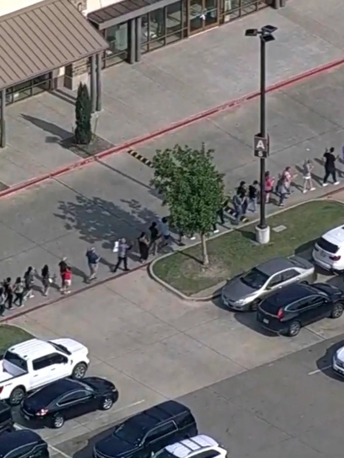 06.05.2023, USA, Allen: In diesem Bild aus einem von der WFAA zur Verfügung gestellten Video werden nach Berichten über Schüsse Menschen aus dem Allen Premium Outlet in Allen, Texas, evakuiert. In dem Einkaufszentrum in einem Vorort der Stadt Dallas sind bei einem Amoklauf mehrere Menschen verletzt worden. Am Samstagabend (Ortszeit) war die Lage noch unklar. Foto: -/WFAA via AP/dpa - ACHTUNG: Nur zur redaktionellen Verwendung und nur mit vollständiger Nennung des vorstehenden Credits +++ dpa-Bildfunk +++