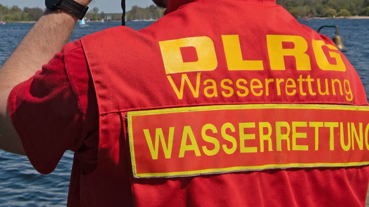 09.05.2021, Berlin: Ein Mitglied der Deutschen Lebensrettungs-Gesellschaft (DLRG) beobachtet die Boote auf dem Wannsee. Ein kurzes Sommerintermezzo kam quasi «über Nacht» und brachte Temperaturen bis zu 30 Grad. Foto: Paul Zinken/dpa +++ dpa-Bildfunk +++