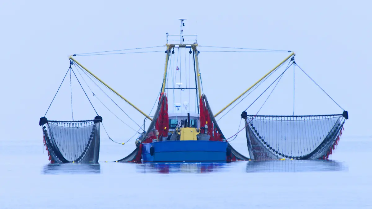 Fischkutter mit ausgeschwenkten Netzen.