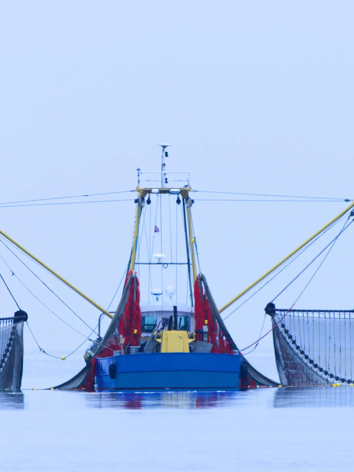 Fischkutter mit ausgeschwenkten Netzen.
