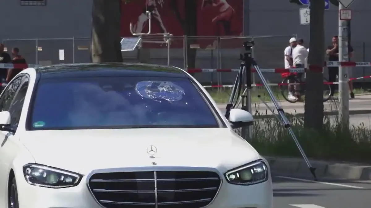 Auf der Frontscheibe des weißen Mercedes sind mehrere Einschusslöcher zu sehen.