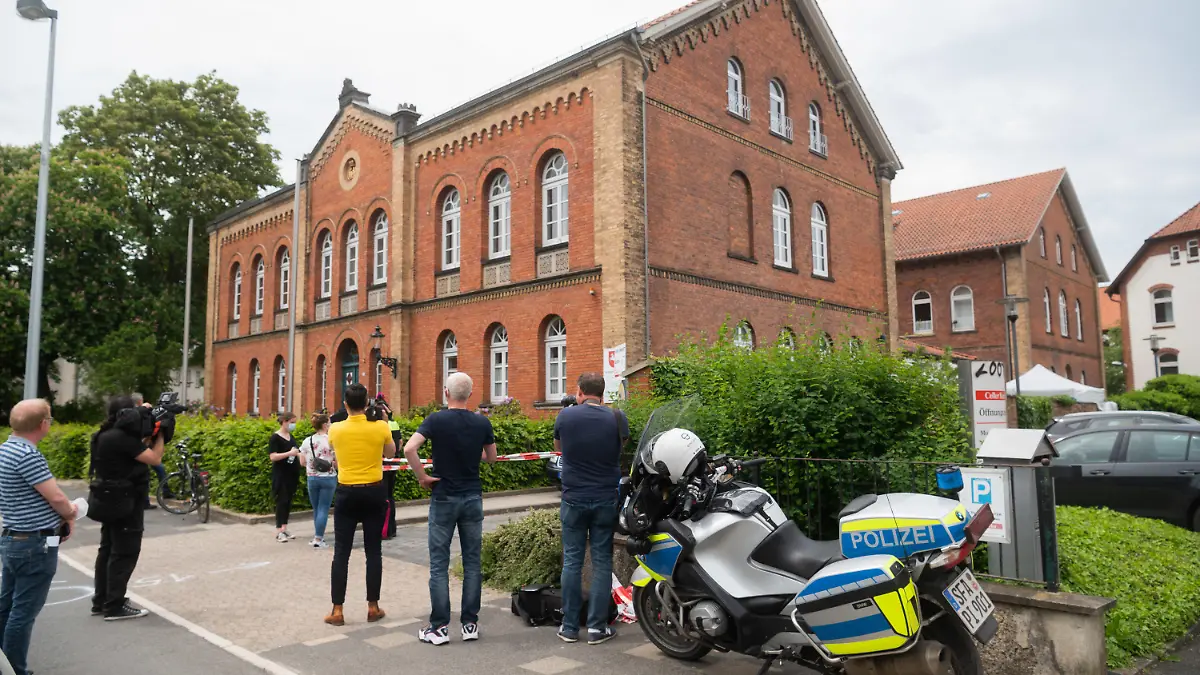 03.06.2021, Niedersachsen, Celle: Polizisten und Journalisten stehen vor dem Amtsgericht Celle. Auf dem Gelände des Amtsgerichts hat ein Mann eine Frau und anschließend sich selbst erschossen. Die Schüsse sind in der Nähe des Eingangs gefallen. Foto: Julian Stratenschulte/dpa +++ dpa-Bildfunk +++