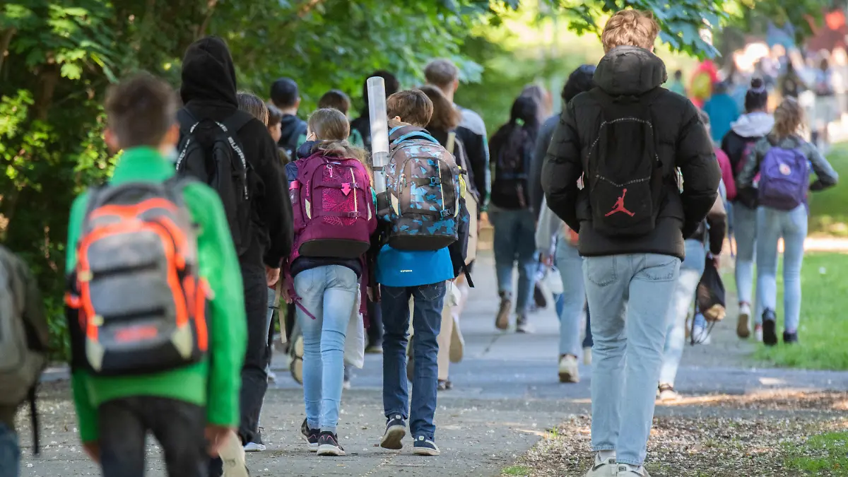 31.05.2021, Niedersachsen, Hannover: Schüler gehen am Morgen zu ihren Schulen. Unter einer Inzidenz von 50 kehren die Schulen und Kitas in Niedersachsen in den Regelbetrieb zurück. Für viele Schüler bedeutet das das erste Wiedersehen in kompletter Klassenstärke seit Monaten. Foto: Julian Stratenschulte/dpa +++ dpa-Bildfunk +++