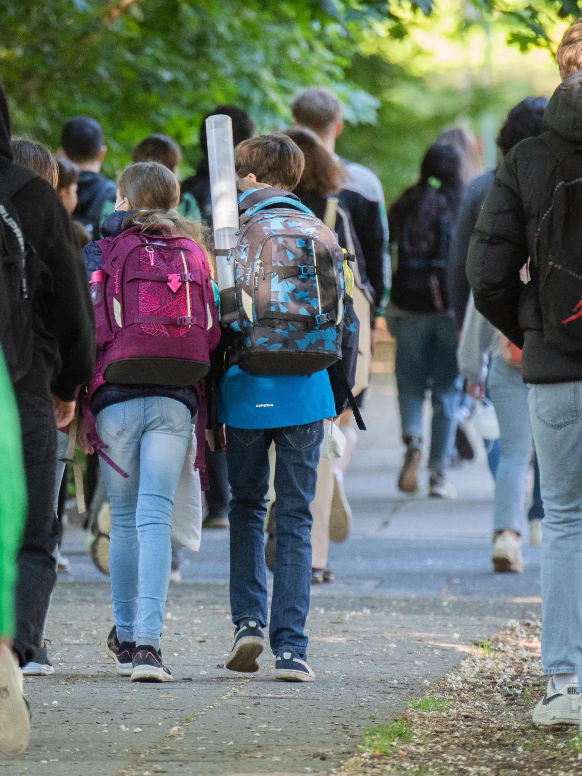 31.05.2021, Niedersachsen, Hannover: Schüler gehen am Morgen zu ihren Schulen. Unter einer Inzidenz von 50 kehren die Schulen und Kitas in Niedersachsen in den Regelbetrieb zurück. Für viele Schüler bedeutet das das erste Wiedersehen in kompletter Klassenstärke seit Monaten. Foto: Julian Stratenschulte/dpa +++ dpa-Bildfunk +++