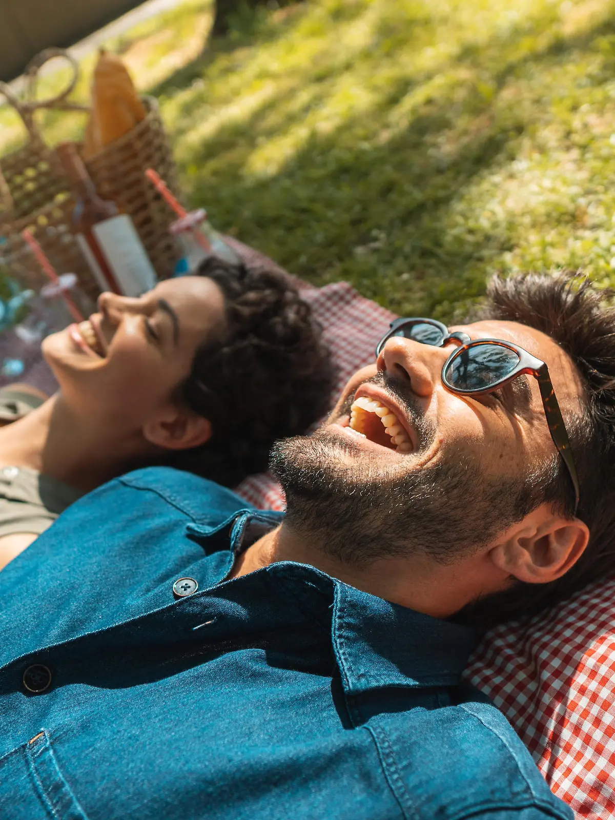 Mann und Frau liegen auf Picknick-Decke im Park