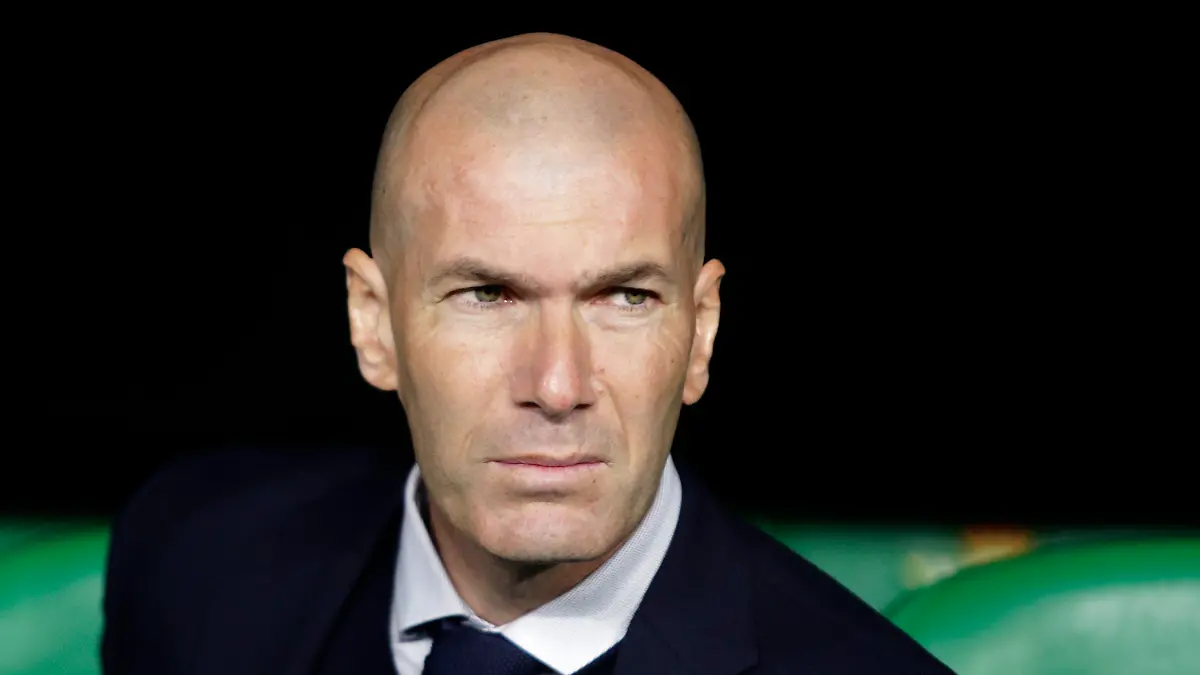 FILE - In this In this file photo dated March 8, 2020, Real Madrid's head coach Zinedine Zidane sits at the bench during La Liga soccer match in Seville, Spain. Zinedine Zidane is again stepping down as Real Madrid coach. The club says the Frenchman is leaving his job. It comes four days after a season in which Madrid failed to win a title for the first time in more than a decade. (AP Photo/Miguel Morenatti, File)