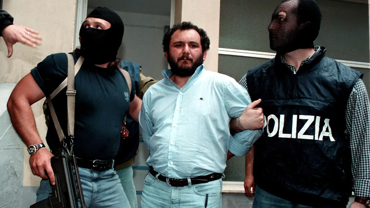 FILE PHOTO: Anti-Mafia police wearing masks to hide their identity, escort top Mafia fugitive Giovani Brusca May 21 as he leaves Palermo's police headquarters to be taken to a maximum security prison. Brusca, accused of mastermining the highway bombing that killed anti-mob judge Giovanni Falcone along with his wife and three bodyguards on May 23, 1992, and is also beleived to have succeeded Salvatore "Toto" Rina as the Mafia's boss of bosses, was arrested with his brother Vincenzo/File Photo