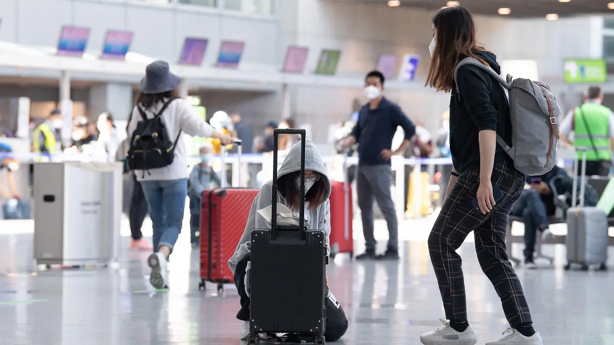 01.06.2021, Hessen, Frankfurt/Main: Passagiere laufen durch das wieder geöffnete Terminal 2 des Flughafens in Frankfurt. Das Terminal war infolge der weltweiten Corona-Pandemie und des daraus resultierenden Rückgangs der Flugverbindungen ein Jahr lang geschlossen worden. Foto: Boris Roessler/dpa +++ dpa-Bildfunk +++