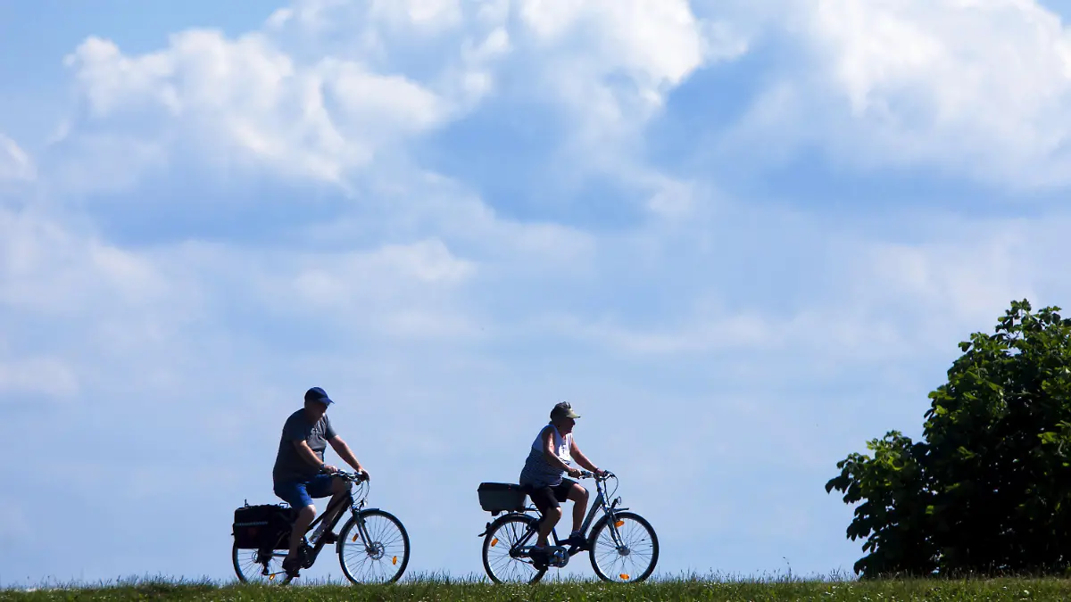 ARCHIV - Urlauber radeln am 25.06.2014 in der Nähe von Zingst (Mecklenburg-Vorpommern) auf der Ostseehalbinsel Fischland-Darß auf dem Deich zum Barther Bodden. Am 10.05.2017 findet in Boizenburg (Mecklenburg-Vorpommern) die Frühjahrsdeichschau mit Umweltminister Backhaus statt. (zu dpa «Frühjahrsdeichschau an der Elbe bei Boizenburg» vom 10.05.2017) Foto: Jens Büttner/dpa-Zentralbild/dpa +++(c) dpa - Bildfunk+++