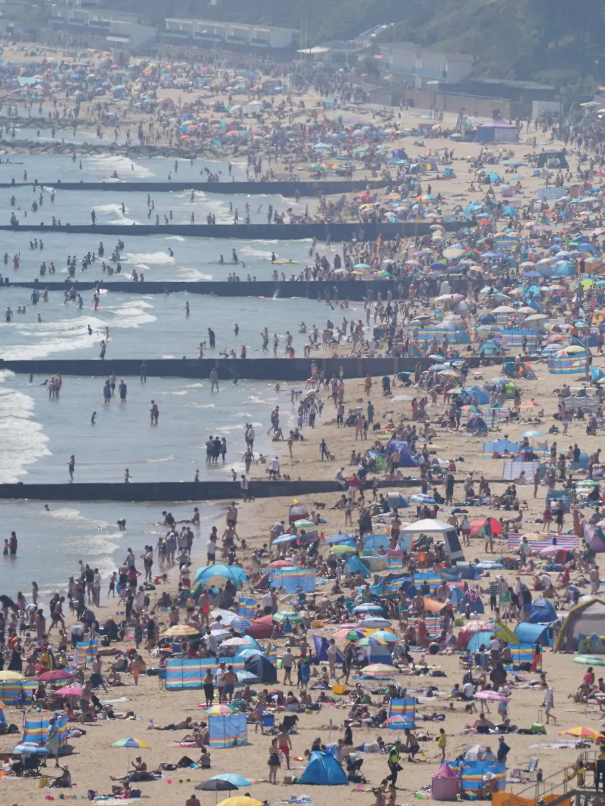 31.05.2021, Großbritannien, Bournemouth: Menschen genießen das warme Wetter am Strand. Der letzte Montag des Monats Mai ist traditionell Feiertag und könnte der bisher heißeste Tag des Jahres werden - mit Temperaturen, die in Teilen des Vereinigten Königreichs 25 Grad erreichen sollen. Foto: Andrew Matthews/PA Wire/dpa +++ dpa-Bildfunk +++