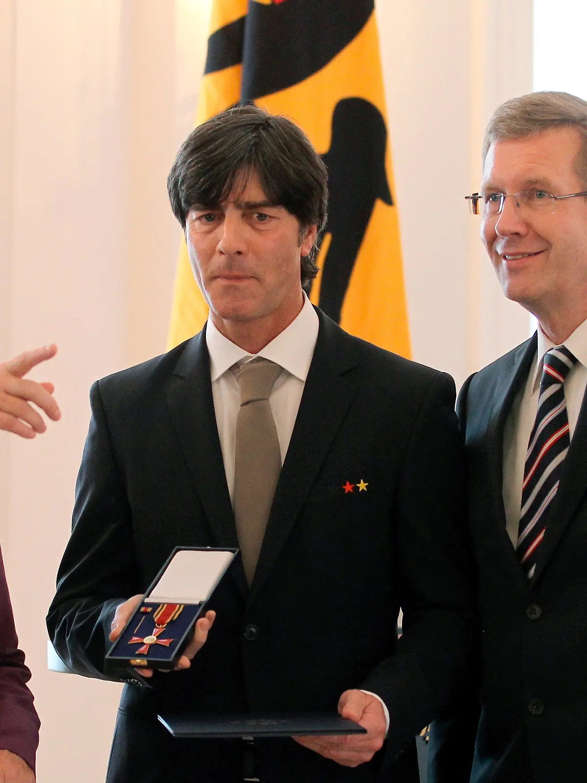 Bundestrainer Joachim Löw (M) bekommt am Dienstag (05.10.2010) im Schloss Bellevue in Berlin das Bundesverdienstkreuz von Bundespräsidenten Christian Wulff  (r)(CDU) übergeben. Links steht Bundeskanzlerin Angela Merkel (CDU). Das deutsche Team und Bundestrainer Joachim Löw werden vom Bundespräsidenten Christian Wulff (CDU) für ihren dritten Platz bei der Fußball-Weltmeisterschaft in Südafrika geehrt. Löw ewrhält den Verdienstorden der Bundesrepublik Deutschland erhalten und die Spieler mit dem Silbernen Lorbeerblatt ausgezeichnet werden. Foto: Wolfgang Kumm dpa/lbn  +++(c) dpa - Bildfunk+++