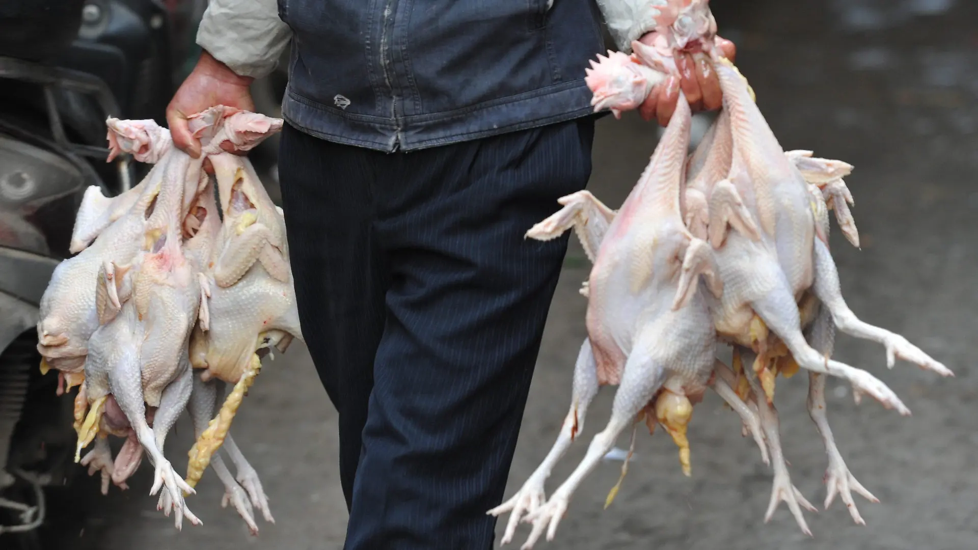 FILE - epa03648362 A vendor carries slaughtered chickens to his stall in a market in Fuyang in central China's Anhui province, 03 April 2013. EPA/AN MING CHINA OUT (zu dpa «Geflügelindustrie möchte Vogelgrippe in China totschweigen» vom 05.02.2014) +++(c) dpa - Bildfunk+++