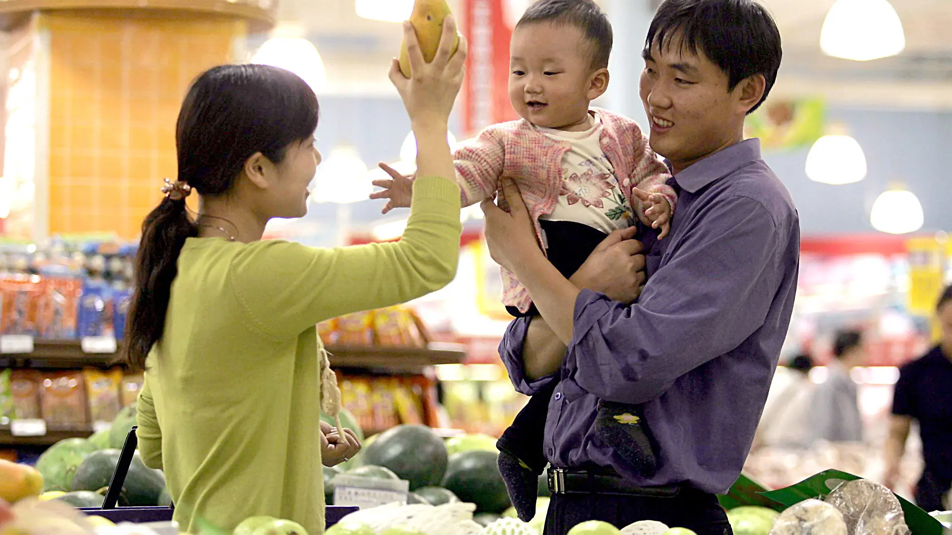 A Chinese couple carrying their kid buy fruits at a supermarket in Shanghai 18 May 2005. Foto: Omp/Imaginechina +++(c) dpa - Report+++