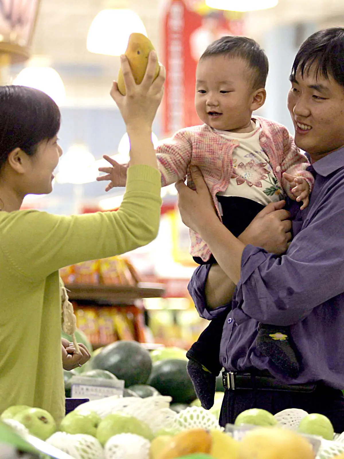 A Chinese couple carrying their kid buy fruits at a supermarket in Shanghai 18 May 2005. Foto:  Omp/Imaginechina +++(c) dpa - Report+++