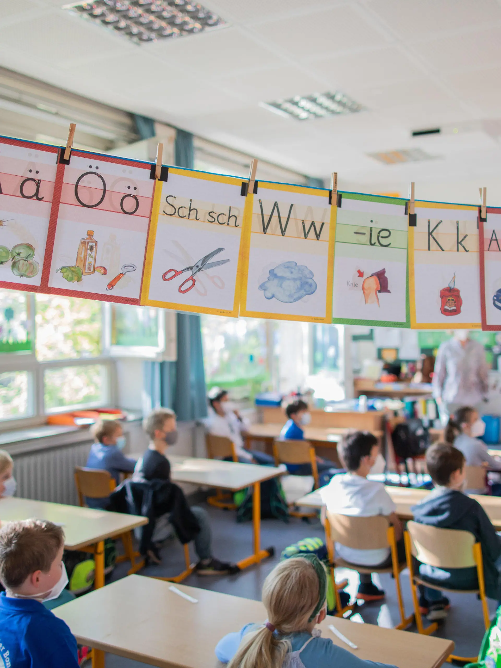 31.05.2021, Nordrhein-Westfalen, Düsseldorf: Schülerinnen und Schüler der Klasse 1B sitzen in ihrem Klassenraum in der Bonifatiusgrundschule. Dank sinkender Corona-Zahlen können die allermeisten Schüler in NRW mit dem Schulbeginn am Montag (31.05.) wieder in den täglichen Präsenzunterricht zurückkehren Foto: Rolf Vennenbernd/dpa - ACHTUNG: Nur zur redaktionellen Verwendung im Zusammenhang mit der aktuellen Berichterstattung und nur mit vollständiger Nennung des vorstehenden Credits +++ dpa-Bildfunk +++