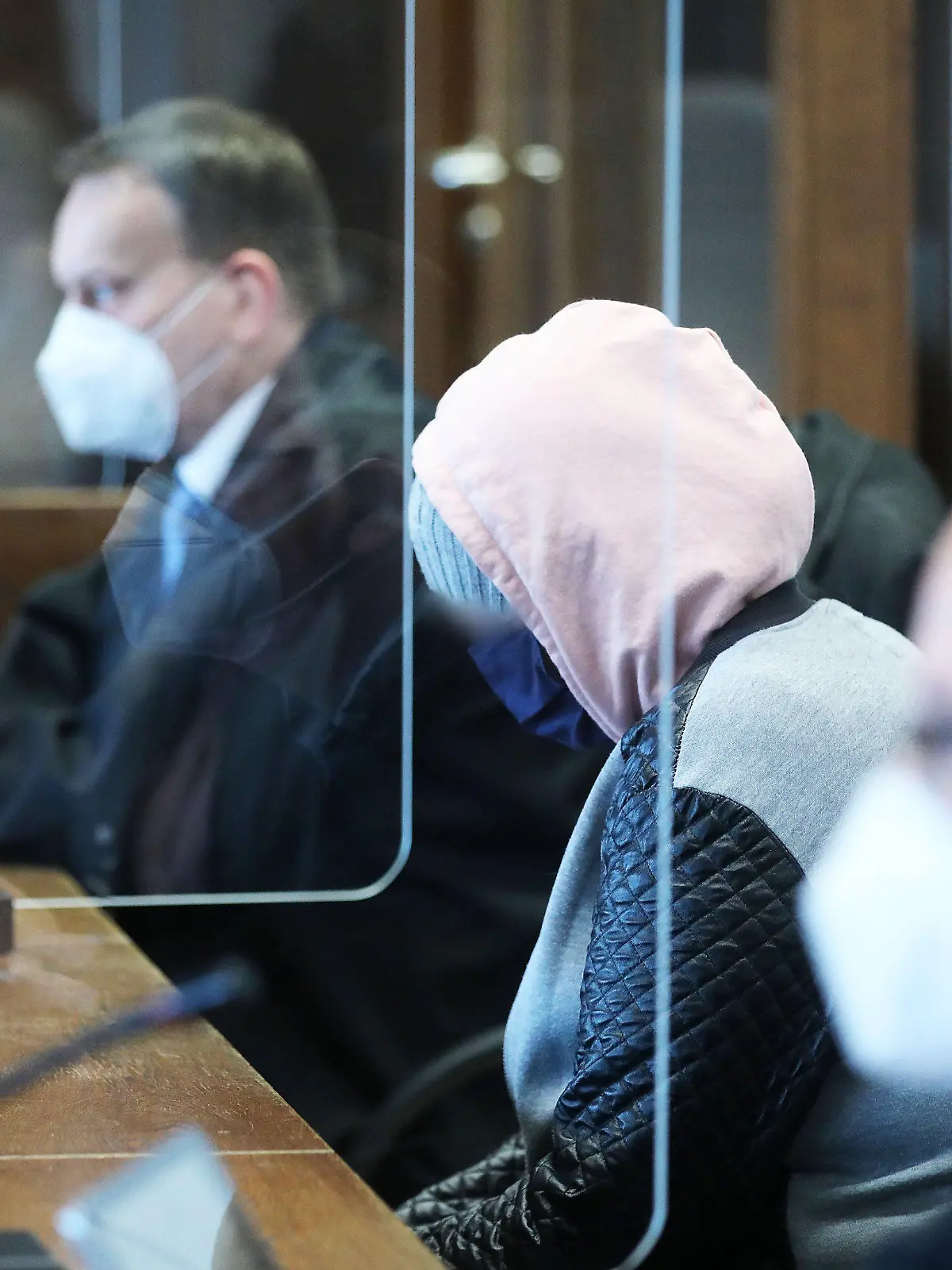 ARCHIV - 12.04.2021, Nordrhein-Westfalen, Köln: Die angeklagte Mutter (M) sitzt zwischen Anwälten im Gerichtssaal. Über Monate soll die Mutter sich nicht um ihre fünfjährige Tochter gekümmert haben. Die Frau und ihr Ex-Freund sind wegen versuchten Mordes angeklagt. Nun wird das Urteil erwartet. (zu dpa: «Mädchen fast verhungert · Urteil gegen Mutter erwartet») Foto: Oliver Berg/dpa - ACHTUNG: Person(en) wurde(n) aus rechtlichen Gründen gepixelt +++ dpa-Bildfunk +++