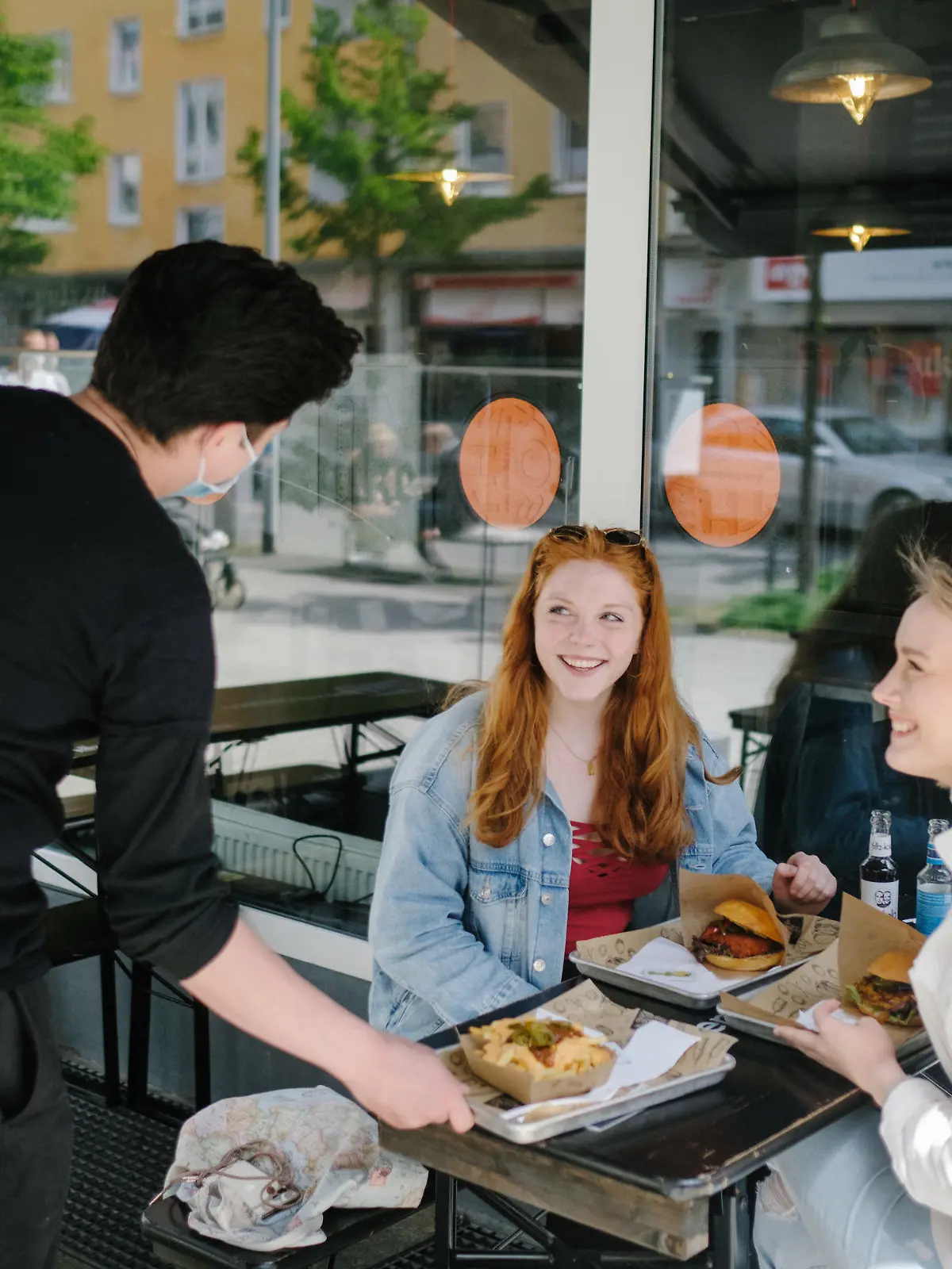 20.05.2021, Niedersachsen, Hannover: Amber (l-r) und Marlene sitzen im Restaurant Duke Burger. Aufgrund sinkenden Corona Inzidenzwerte lockert die Region Hannover ihre Corona-Bestimmungen. Foto: Ole Spata/dpa +++ dpa-Bildfunk +++