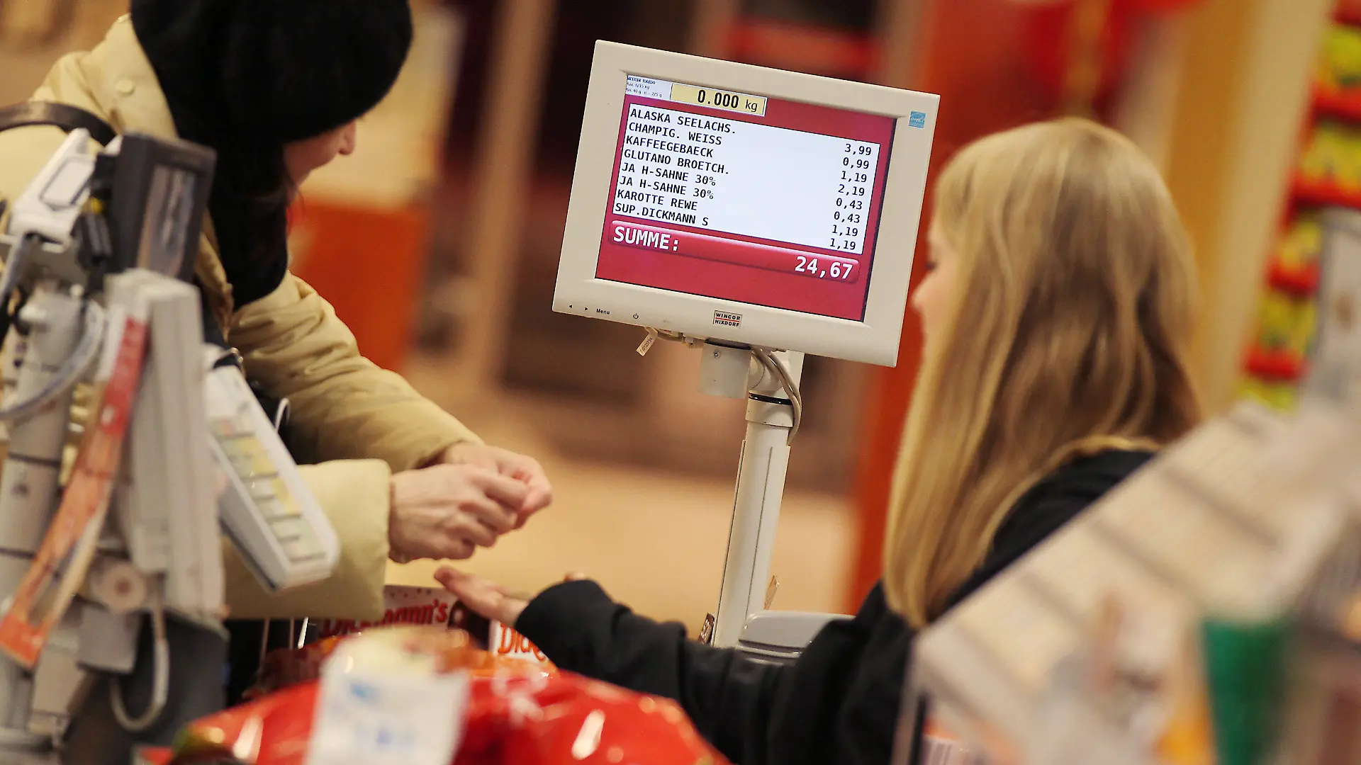 ARCHIV - 13.02.2012, Nordrhein-Westfalen, Köln: Eine Kassiererin nimmt in einem Supermarkt das Geld einer Kundin entgegen. Der Einkauf im Internet wird immer beliebter. Rund zwei Drittel der Deutschen shoppen inzwischen zumindest gelegentlich online. Die Händler in den Einkaufsstraßen müssen deshalb besser werden. (zu dpa " Umfrage: Am meisten nervt beim Einkauf die Schlange an der Kasse" vom 30.03.2018) Foto: Oliver Berg/dpa +++ dpa-Bildfunk +++
