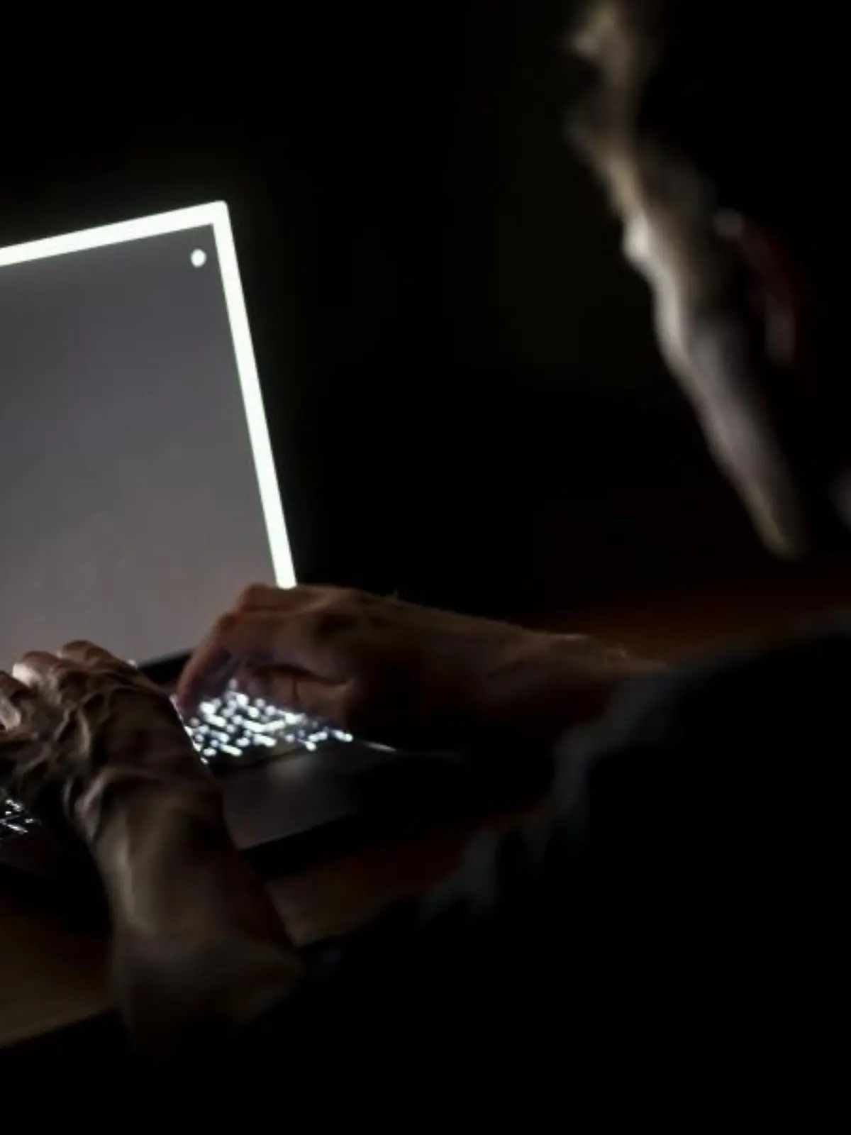 Ein Mann schreibt auf der Tastatur eines Laptops