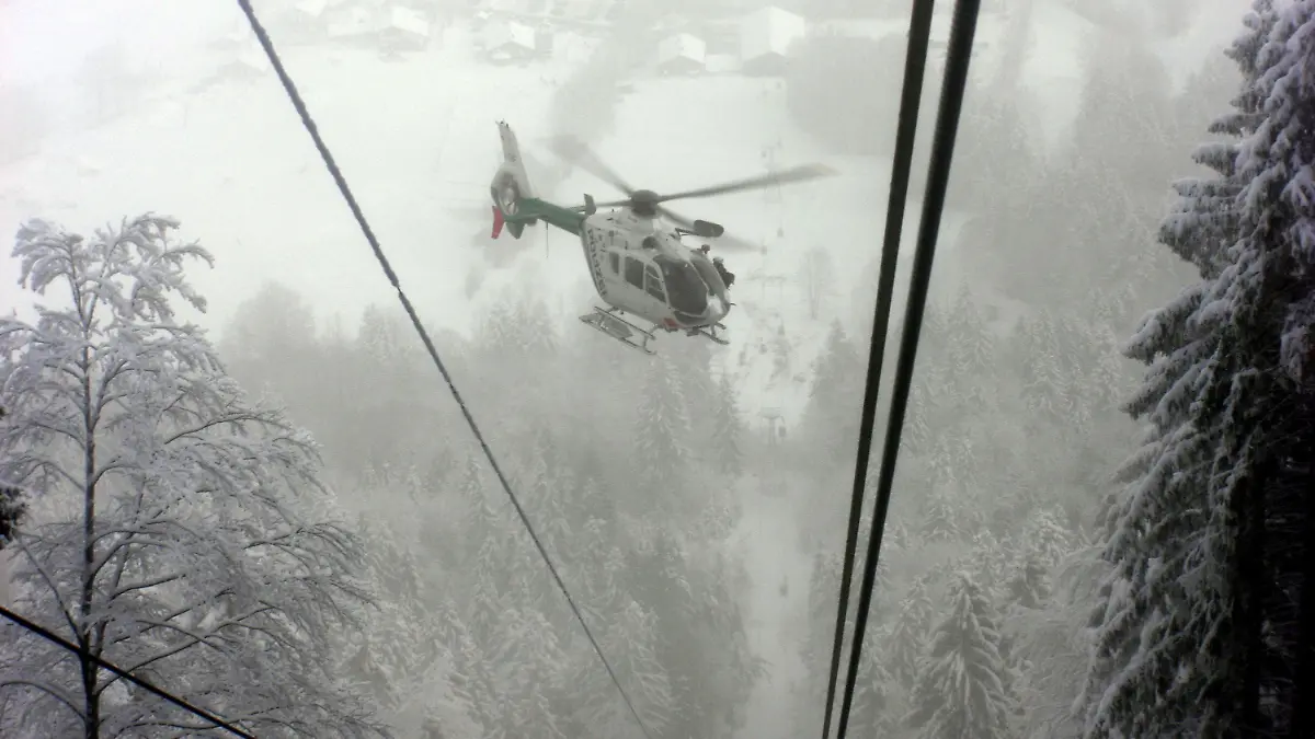 Ein Polizeihubschrauber fliegt am Dienstag (12.01.2010) über der Seilbahn am Brauneck in Lenggries (Oberbayern), aufgenommen von einem Betroffenen aus einer der Gondeln heraus. Nach einem Totalausfall des Seilbahnbetriebes saßen rund 60 Fahrgäste mehrere Stunden in ihren Gondeln fest. Alle Fahrgäste konnten unverletzt aus den Gondeln geborgen werden. Foto: Peter Gutmann dpa/lby  +++(c) dpa - Bildfunk+++