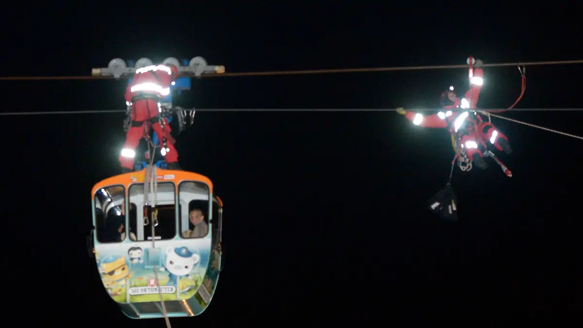 Höhenretter der Berufsfeuerwehr der Stadt Köln seilen am 21.11.2014 in Köln (Nordrhein-Westfalen) eine vierköpfige Familie aus einer Gondel der Rheinseilbahn ab. Wegen eines heftigen Sturms blieb die Bahn über dem Rhein stehen, die Familie musste gerettet werden. Foto: Roberto Pfeil/dpa +++(c) dpa - Bildfunk+++