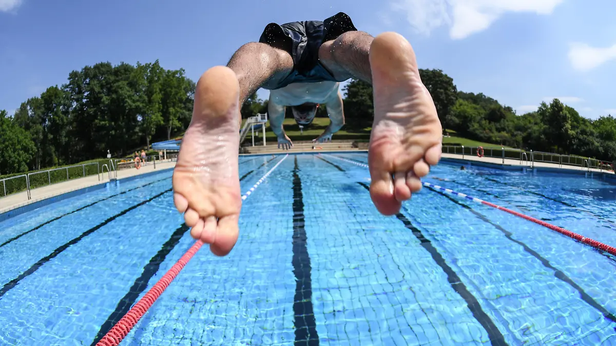 ARCHIV - 29.06.2018, Hessen, Darmstadt-Eberstadt: Ein Schwimmer stößt sich bei sommerlichen Temperaturen von einem Startblock des Mühltalbads im Stadtteil Eberstadt ab. (zu dpa «Freibad-Saison 2020 in Hessen: Eine Bilanz») Foto: Arne Dedert/dpa +++ dpa-Bildfunk +++