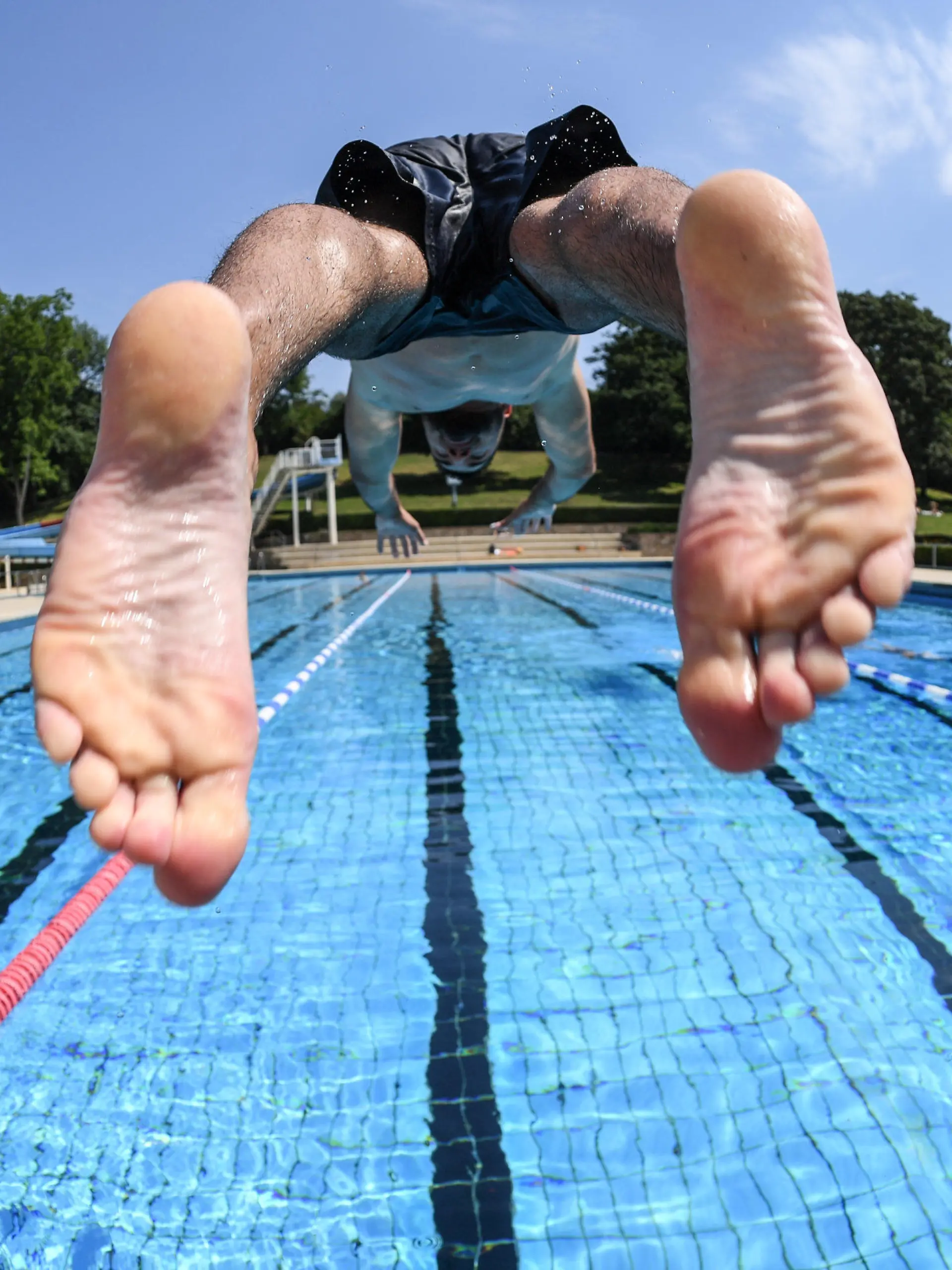 ARCHIV - 29.06.2018, Hessen, Darmstadt-Eberstadt: Ein Schwimmer stößt sich bei sommerlichen Temperaturen von einem Startblock des Mühltalbads im Stadtteil Eberstadt ab. (zu dpa «Freibad-Saison 2020 in Hessen: Eine Bilanz») Foto: Arne Dedert/dpa +++ dpa-Bildfunk +++