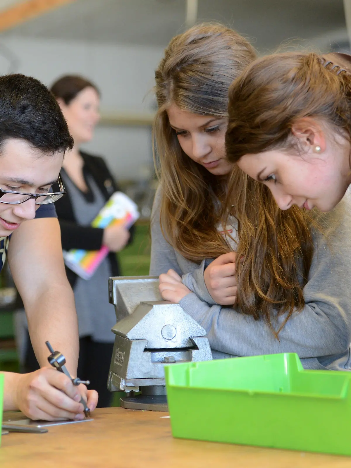 Azubi Emre erklärt am 12.03.2014 in Schwaigern (Baden-Württemberg) während der Girls'Day-Akademie in der Firma Walter Söhner den Schülerinnen Tamara (l) und Dajana die Arbeitsschritte. Foto: Franziska Kraufmann/dpa    (zu dpa "Ein Jahr statt ein Tag: «Girl's Day» wird zur Akademie ausgebaut" vom 21.03.2014) +++(c) dpa - Bildfunk+++