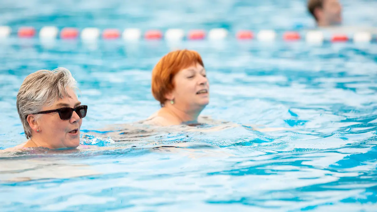 13.05.2021, Niedersachsen, Hannover: Zwei Frauen schwimmen in einem Becken vom Freibad Lister Bad. Hannover eröffnet von dem heutigen Donnerstag (13.05.2021) an die Freibadsaison. Allerdings gelten in der Corona-Pandemie besondere Regeln: allein, zu zweit oder mit Personen des eigenen Haushaltes können Schwimmer demnach eine 50-Meter-Bahn, ein halbes Nichtschwimmerbecken oder ein halbes Sprungbecken für eine Stunde anmieten. Nur jeweils vier der acht Bahnen in den 50-Meter-Becken werden vermietet - um die Abstandsregeln einhalten zu können. Foto: Moritz Frankenberg/dpa +++ dpa-Bildfunk +++