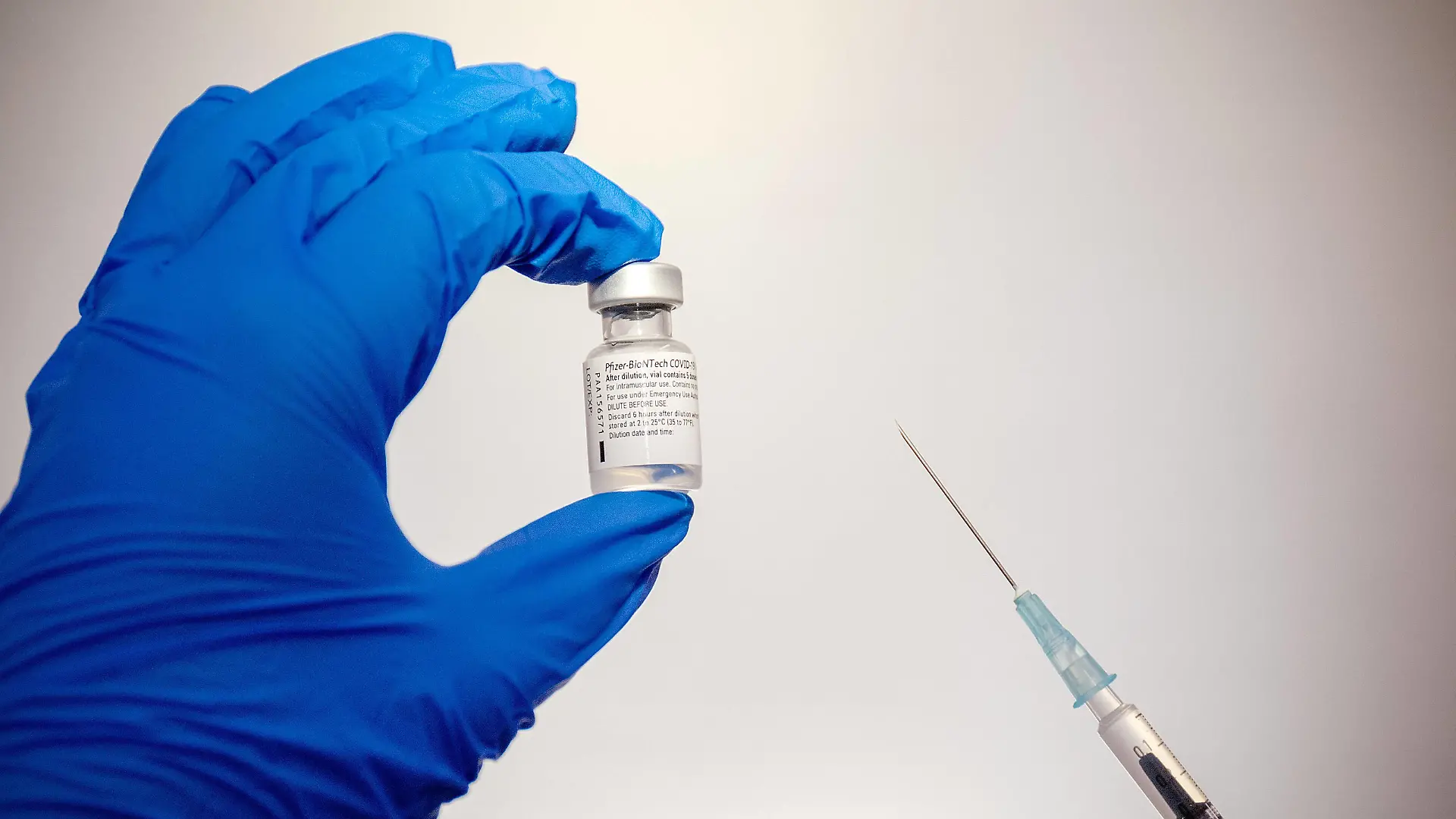 Duesseldorf, Deutschland 02. Februar 2021: Eine Ampulle mit dem Impfstoff gegen Covid-19 von Pfizer-BioNTech wird in der linken Hand gehalten und die Spritze mit dem aufgezogenen Impfstoff Nordrhein Westfalen *** Duesseldorf, Germany 02 February 2021 An ampoule containing Pfizer BioNTechs Covid 19 vaccine is held in the left hand and the syringe with the vaccine drawn up Nordrhein Westfalen Copyright: xFotostandx/xWundrigx