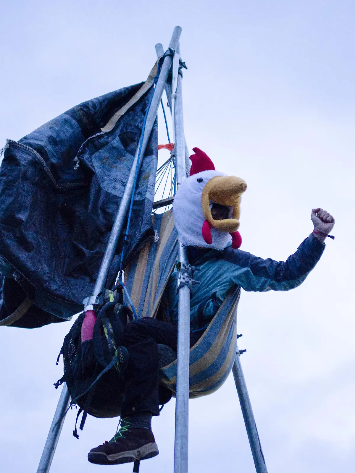 Aktivist im Dreibeingestell blockiert die Zufahrt zum Firmengelände