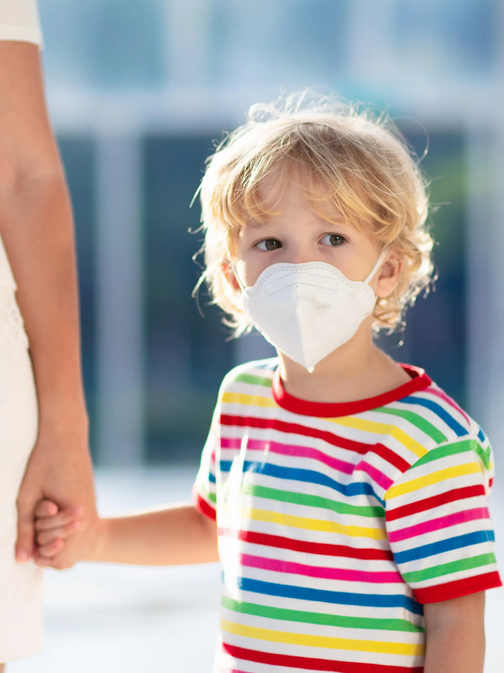 Mutter geht mit Kind mit Mundschutz spazieren