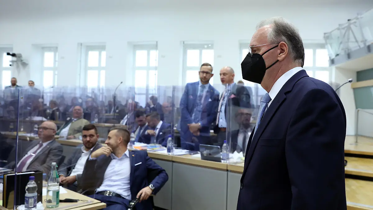 16.09.2021, Sachsen-Anhalt, Magdeburg: Reiner Haseloff (CDU), geschäftsführender Ministerpräsident von Sachsen-Anhalt, betritt vor Beginn des zweiten Wahlgangs den Plenarsaal im Landtag von Sachsen-Anhalt, während im Hintergrund Abgeordnete der AfD-Fraktion zu sehen sind. Haseloff stellt sich zur Wiederwahl als Ministerpräsident. Er fiel im ersten Wahlgang durch. Foto: Ronny Hartmann/dpa +++ dpa-Bildfunk +++