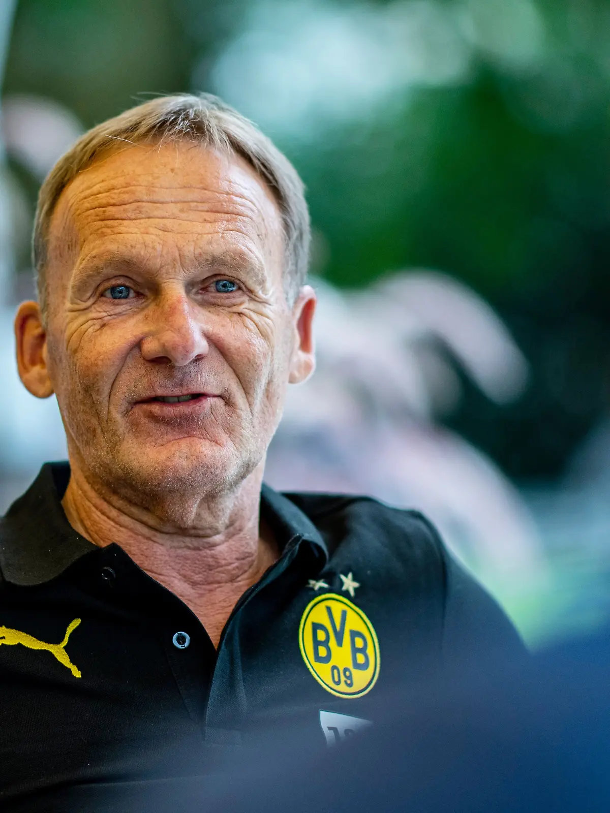 ARCHIV - 13.08.2020, Schweiz, Bad Ragaz: Fußball: Bundesliga, Trainingslager von Borussia Dortmund in Bad Ragaz (Schweiz). Hans-Joachim Watzke, Geschäftsführer von Borussia Dortmund (BVB), spricht in einem Interview auf der Terrasse des Mannschaftshotels Grand Resort Bad Ragaz. (zu dpa "Watzke: BVB ist den Bayern näher gekommen - auf Schlagdistanz") Foto: David Inderlied/dpa +++ dpa-Bildfunk +++