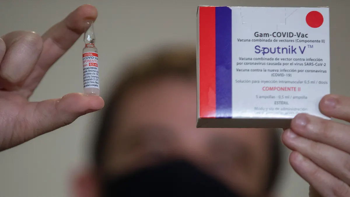 A Uniao Quimica pharmaceutical employee holds a vial at the company's control center for the Russian Sputnik V COVID-19 vaccine during a press conference in Guarulhos in the greater Sao Paulo area of Brazil, Thursday, May 20, 2021. The Sputnik V vaccine still hasn't been approved for use in Brazil, which prompted local partner Uniao Quimica to begin exports throughout Latin America. (AP Photo/Andre Penner)