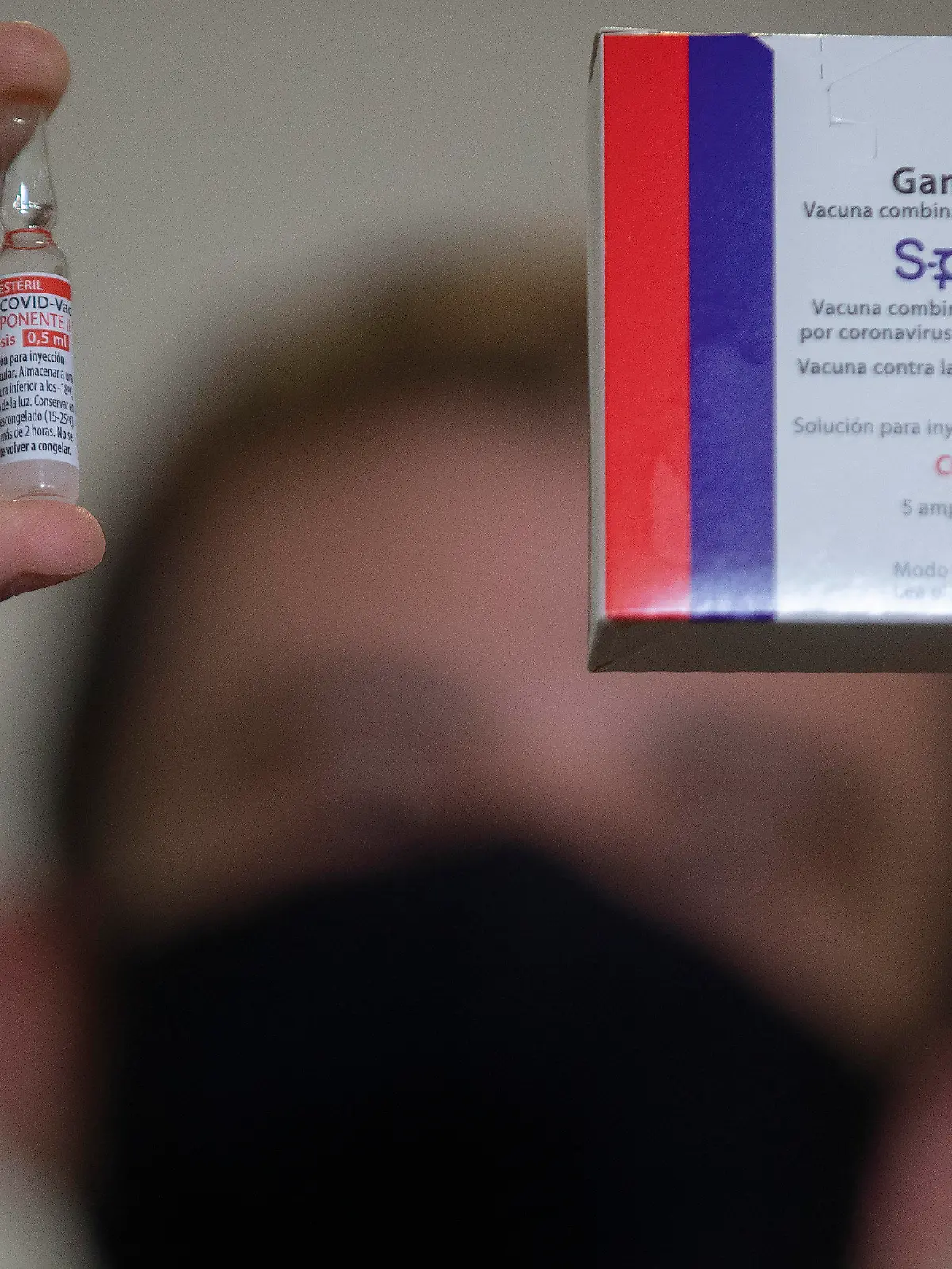A Uniao Quimica pharmaceutical employee holds a vial at the company's control center for the Russian Sputnik V COVID-19 vaccine during a press conference in Guarulhos in the greater Sao Paulo area of Brazil, Thursday, May 20, 2021. The Sputnik V vaccine still hasn't been approved for use in Brazil, which prompted local partner Uniao Quimica to begin exports throughout Latin America. (AP Photo/Andre Penner)