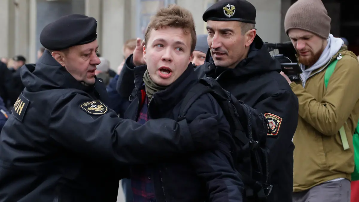 FILE - In this Sunday, March 26, 2017 file photo, Belarus police detain journalist Raman Pratasevich, center, in Minsk, Belarus. Raman Pratasevich, a founder of a messaging app channel that has been a key information conduit for opponents of Belarus’ authoritarian president, has been arrested after an airliner in which he was riding was diverted to Belarus because of a bomb threat. The presidential press service said President Alexander Lukashenko personally ordered that a MiG-29 fighter jet accompany the Ryanair plane — traveling from Athens, Greece, to Vilnius, Lithuania — to the Minsk airport. ﻿﻿(AP Photo/Sergei Grits, File)
