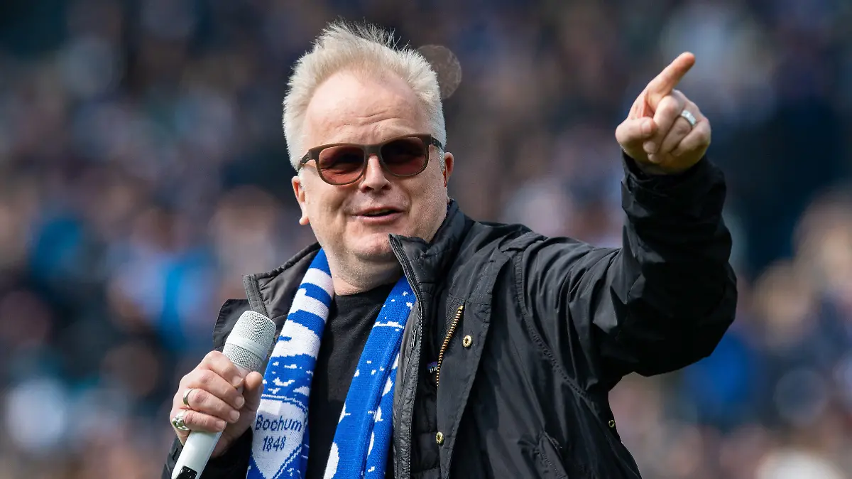 ARCHIV - 14.04.2019, Nordrhein-Westfalen, Bochum: Herbert Grönemeyer singt vor dem Spiel der 2. Bundesliga VfL Bochum gegen Greuther Fürth im Vonovia Ruhrstadion den Song «Bochum». Herbert Grönemeyer wird am 12. April 65 Jahre alt, gehört zu den Top-Stars des deutschen Rock, gilt vielen gar als Stimme der Nation und findet auch mit seinem sozialpolitischen Engagement immer wieder Gehör. (zu dpa: «Herbert Arthur Wiglev Clamor Grönemeyer ist Musiker, Texter, Sänger, Produzent und Schauspieler») Foto: Guido Kirchner/dpa +++ dpa-Bildfunk +++