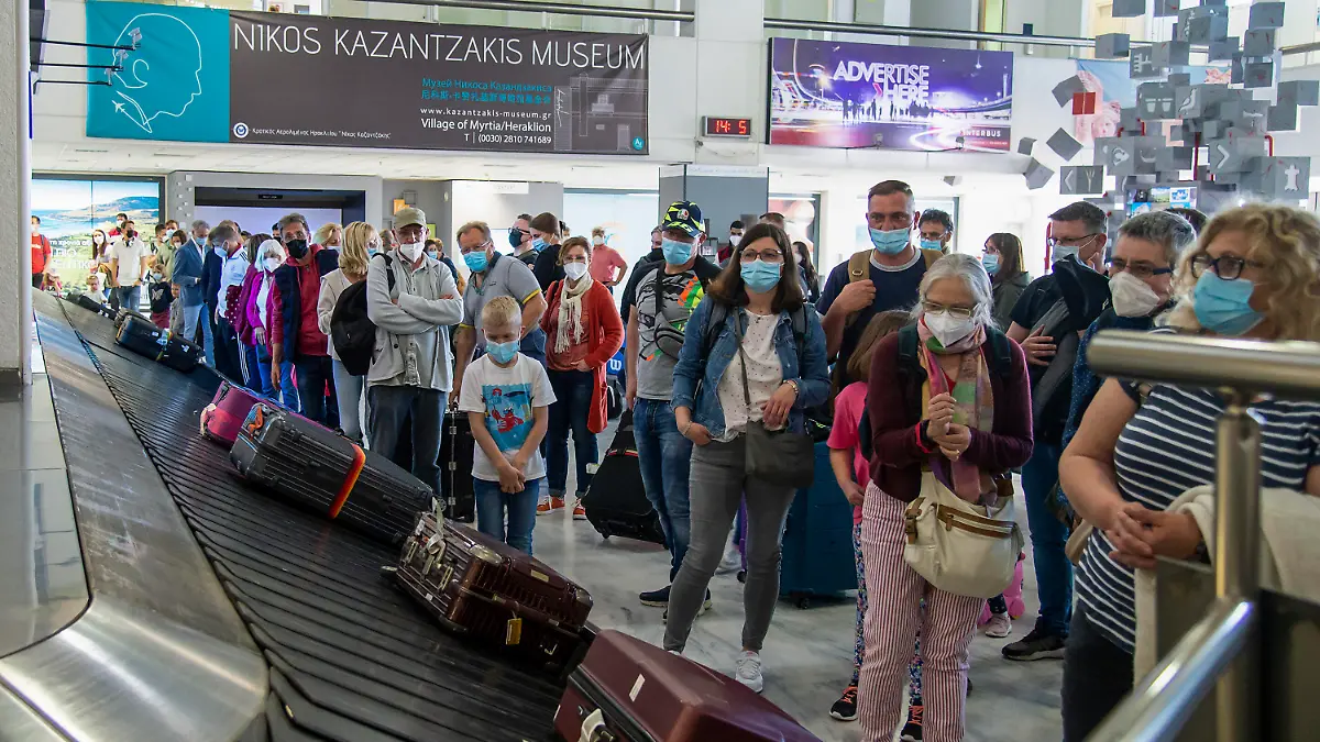 14.05.2021, Griechenland, Kreta: Passagiere aus Hannover warten am internationalen Flughafen Nikos Kazantzakis auf ihr Gepäck. Landesweit wurden die coronabedingten Maßnahmen zum Start der Tourismus-Saison gelockert. Foto: Harry Nakos/AP/dpa +++ dpa-Bildfunk +++