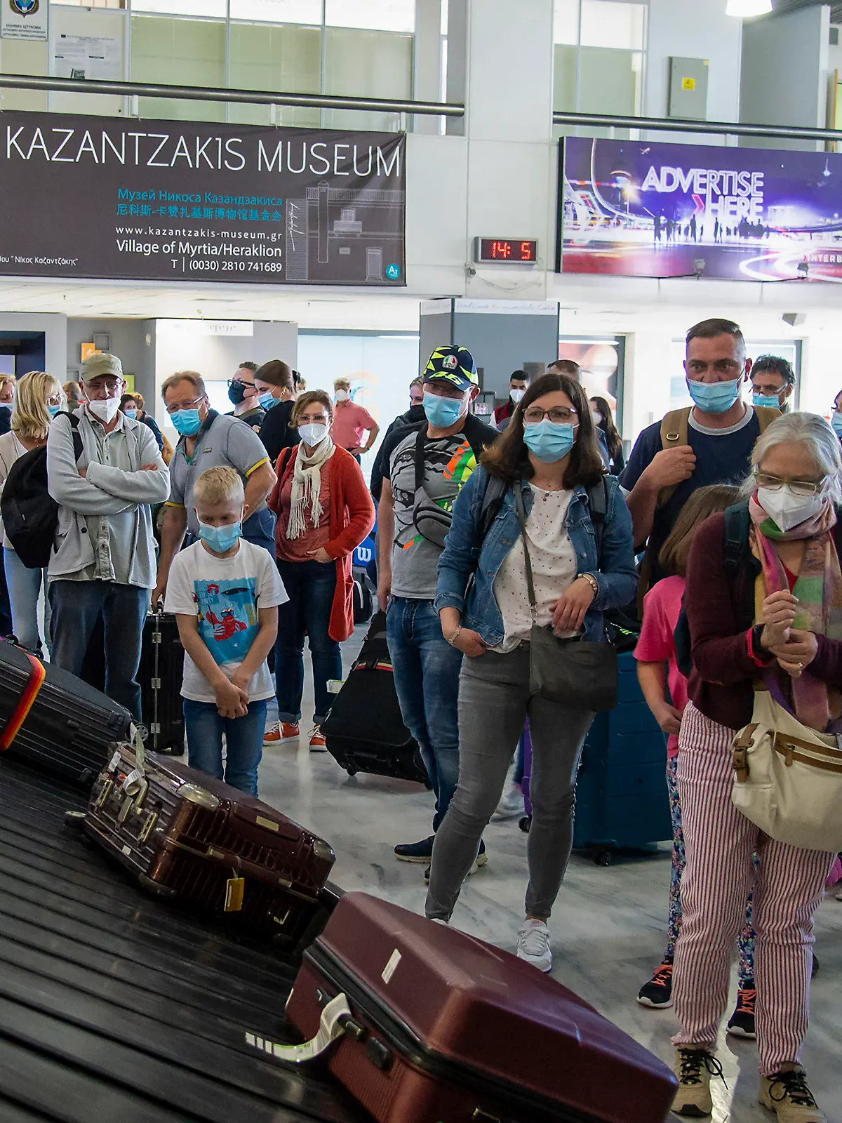 14.05.2021, Griechenland, Kreta: Passagiere aus Hannover warten am internationalen Flughafen Nikos Kazantzakis auf ihr Gepäck. Landesweit wurden die coronabedingten Maßnahmen zum Start der Tourismus-Saison gelockert. Foto: Harry Nakos/AP/dpa +++ dpa-Bildfunk +++